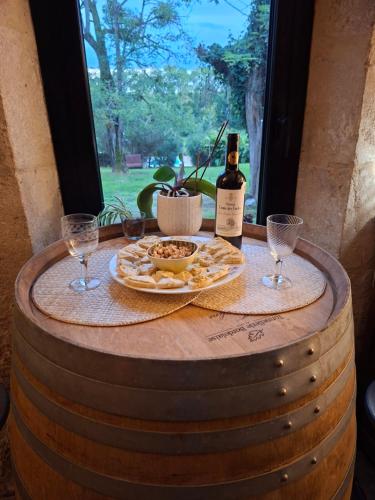 a table with a plate of food and a bottle of wine at Chambres 2 personnes dans notre maison Girondine in Saint-Martin-de-Lerm