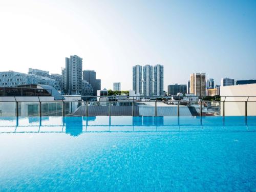 a swimming pool with a city skyline in the background at Mercure Singapore Tyrwhitt in Singapore