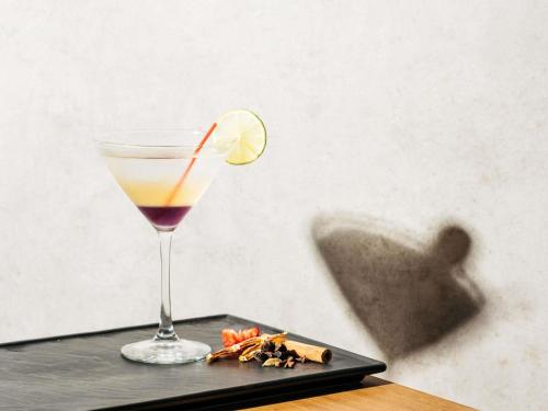 a drink on a black tray with a slice of lime at Mercure Singapore Tyrwhitt in Singapore