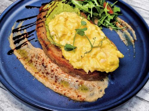 a blue plate of food with eggs on a piece of bread at Mercure Singapore Tyrwhitt in Singapore