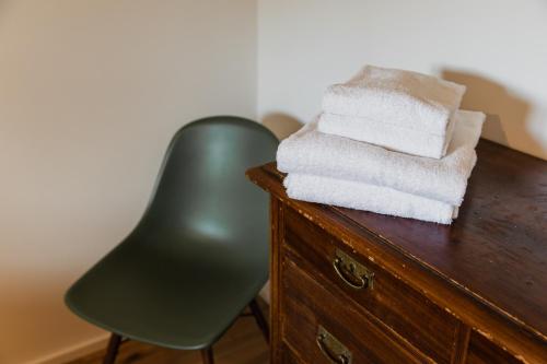 a pile of towels sitting on top of a wooden dresser at HØV - Boutique-Apartments im Allgäu - Rückzug & Design in Altusried