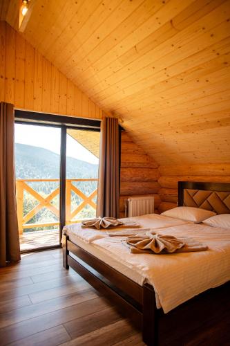 a bedroom with a bed and a large window at Magura Resort in Yablunytsya