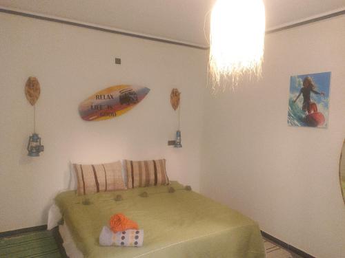 a bedroom with a bed with a surfboard on the wall at auberge Brava Tifnit 