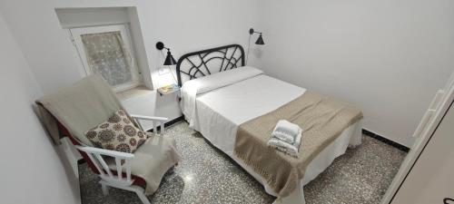 ein Schlafzimmer mit einem Bett, einem Stuhl und einem Fenster in der Unterkunft La Casa de Antonina in Castilblanco de los Arroyos