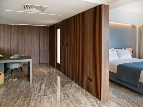 a hotel room with a bed and a desk at Mercure Larnaca Beach Resort in Larnaka