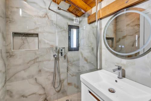 a bathroom with a shower and a sink and a mirror at Villa Soni in Berat