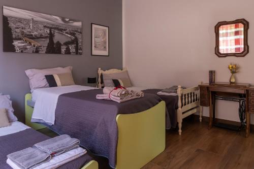 a bedroom with two beds and a crib and a mirror at Le Giare House in Grezzana
