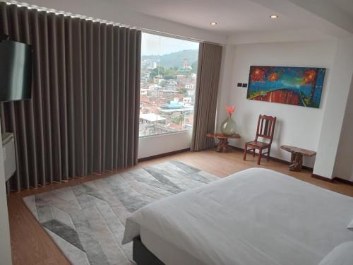 a bedroom with a bed and a large window at Terraza De San Antonio in Cali