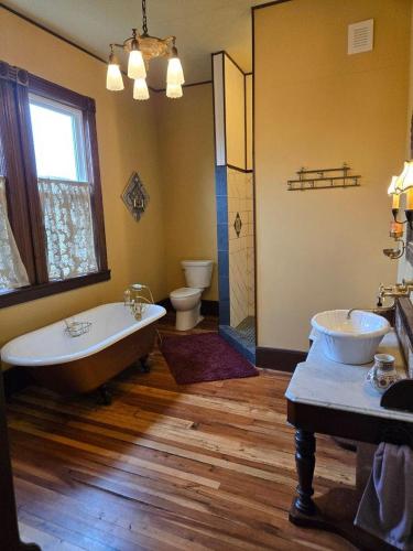 a bathroom with two sinks and a tub and two toilets at The Parker House Bed and Breakfast in Bath