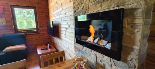 a living room with a fireplace in the wall at Domki Bursztyn in Święta Katarzyna