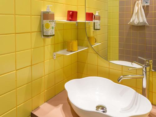 a yellow bathroom with a toilet and a sink at greet hôtel Pont du Gard - Route d'Avignon in Estézargues
