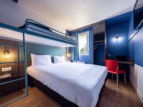 a bedroom with a large bed and a red chair at greet Chartres Est in Chartres