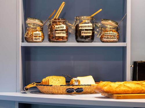 a shelf with bread and jam and a basket of bread at greet Chartres Est in Chartres