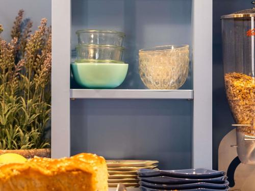 a shelf with bowls and other items on it at greet Chartres Est in Chartres