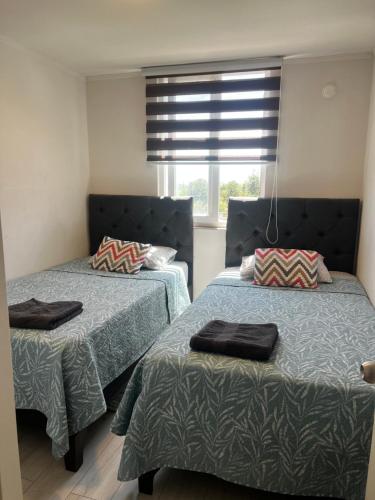 a bedroom with two beds and a window at Departamento safari 2 habitaciones 2 baños in Rancagua
