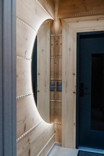 a room with a wooden wall and a door at Domki Osada Klenina SAUNA & BALIA in Kamienica