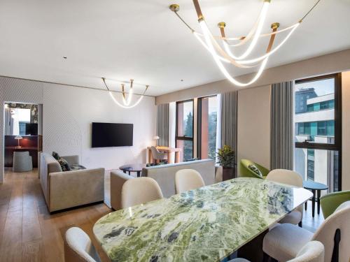 a living room with a dining table and a living room with a couch at Swissôtel Tbilisi in Tbilisi City