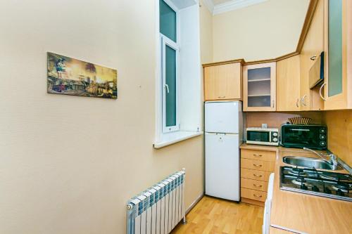 una piccola cucina con frigorifero e microonde di ISKCON Apartment a Baku