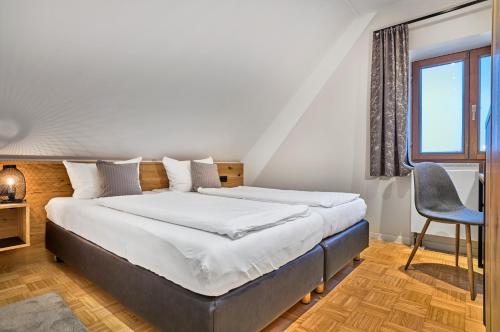 a bedroom with a bed and a chair and a window at Gasthaus Hotel Ostermeier in Attenkirchen