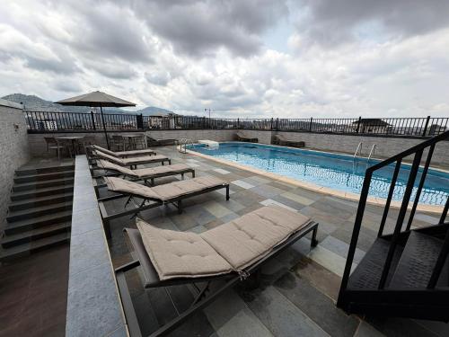 una piscina con tumbonas en un edificio en TRENDY RESIDENCE - Luxury Serviced Apartments in Bastos, en Yaoundé