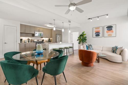 a living room with a glass table and green chairs at The Amber Serene Peaceful Retreat Pool Gym And Jacuzzi in Los Angeles