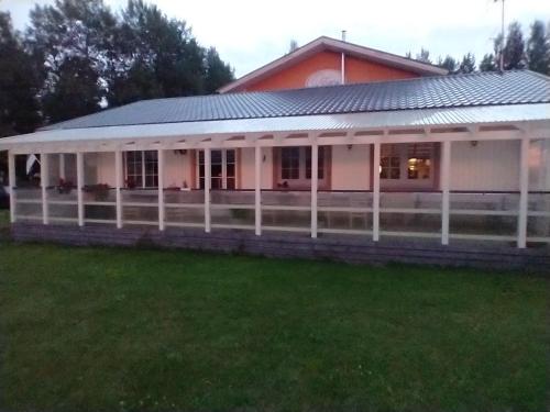 a white house with a fence in the yard at Camping Kohvikann in Võsupere