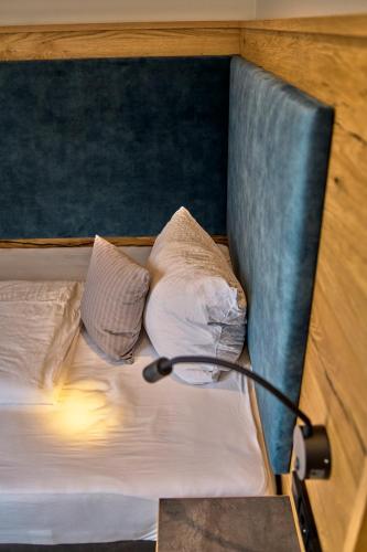 a bed with two pillows and a lamp on it at Gasthaus Hotel Ostermeier in Attenkirchen