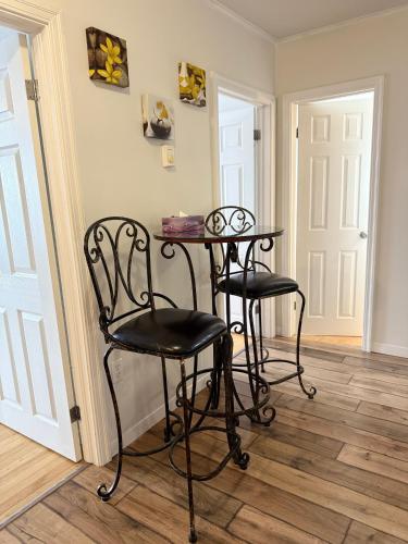 a table and two chairs in a room with a door at Airport Manor Unit 4, 2 Bedroom Apartment in Torbay