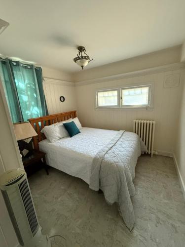 a bedroom with a bed and two windows at Midstream Manor Unit 10, 2 Bedroom Apartment in St. John's