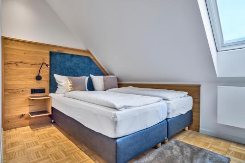 a bedroom with a large bed with a blue headboard at Gasthaus Hotel Ostermeier in Attenkirchen