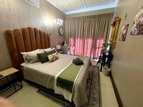 a bedroom with a large bed and a window at Potch Manor Boutique Guest House in Potchefstroom