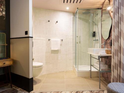 a bathroom with a shower and a toilet and a sink at Hotel Les Capitouls Toulouse Centre - Handwritten Collection in Toulouse