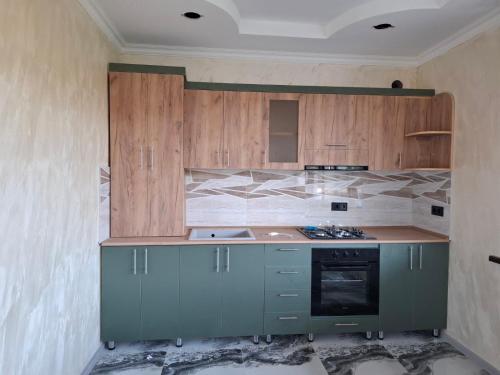 a kitchen with wooden cabinets and a stove top oven at Lori Hills Agritourism in Gyulagarak