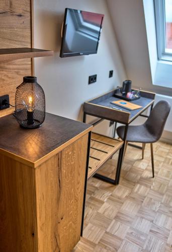 a room with a desk and a tv on the wall at Gasthaus Hotel Ostermeier in Attenkirchen
