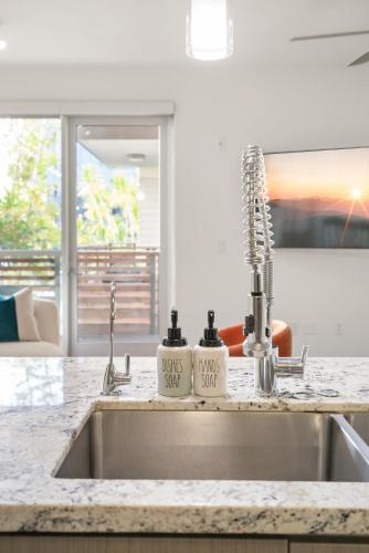 a kitchen sink with two soap bottles on it at The Amber Serene Peaceful Retreat Pool Gym And Jacuzzi in Los Angeles