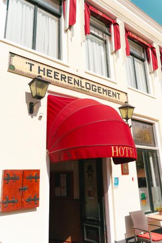a red awning on the front of a hotel at Hotel Restaurant 't Heerenlogement in Harlingen