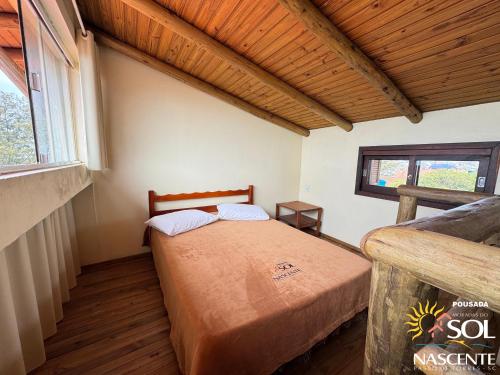 a bedroom with a bed and a window at Pousada Moradas do Sol Nascente in Passo de Torres