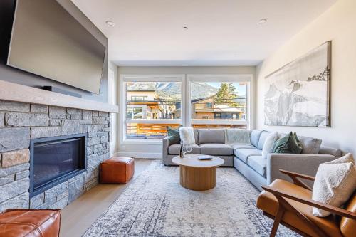 a living room with a couch and a fireplace at Aurora Luxe - Stunning Townhouse Private Hot Tub in Canmore