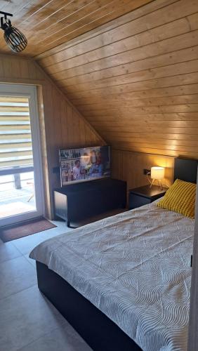 a bedroom with a large bed in a room with a window at Ūdros slėnis in Bildžiai