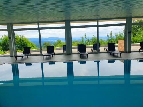 a swimming pool with chairs and a view of the mountains at Ferienwohnung Yvonne in Freyung