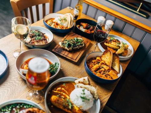 a table with plates of food and glasses of wine at ibis Coleraine Riverside in Coleraine