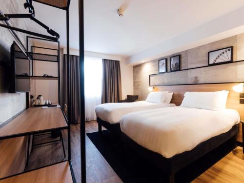 a hotel room with two beds and a television at ibis Coleraine Riverside in Coleraine