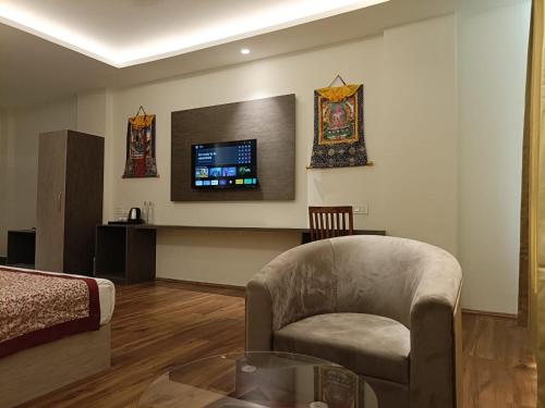 a living room with a chair and a tv on the wall at Zambala residency & spa in Gangtok