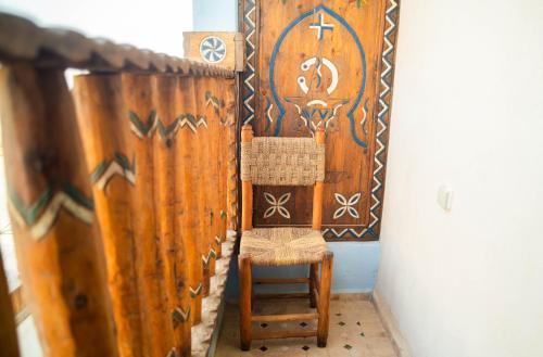 a wooden room with a chair and a curtain at Imsouane WOOD HOUSE in Imsouane