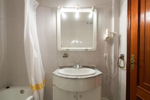 a white bathroom with a sink and a mirror at My Rooms City Hotel Monte Blanco in Neaño