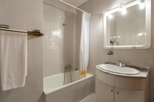 a bathroom with a sink and a tub and a mirror at My Rooms City Hotel Monte Blanco in Neaño