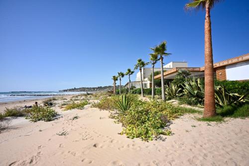 a sandy beach with palm trees and the ocean at Ristorante Hotel DA VITTORIO in Menfi
