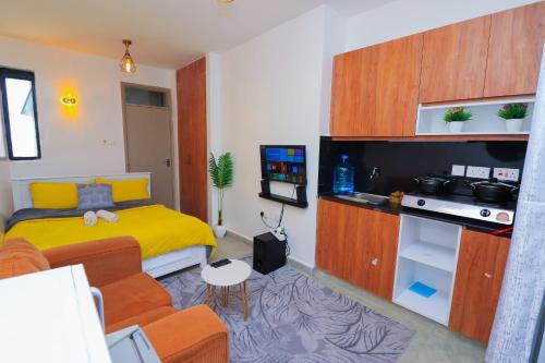a small room with a bed and a kitchen at Comfort Homes Roysambu in Nairobi