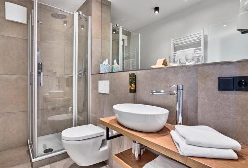a bathroom with a sink and a toilet and a shower at Gasthaus Hotel Ostermeier in Attenkirchen