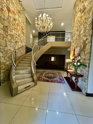 a staircase in a house with a chandelier at Potch Manor Boutique Guest House in Potchefstroom